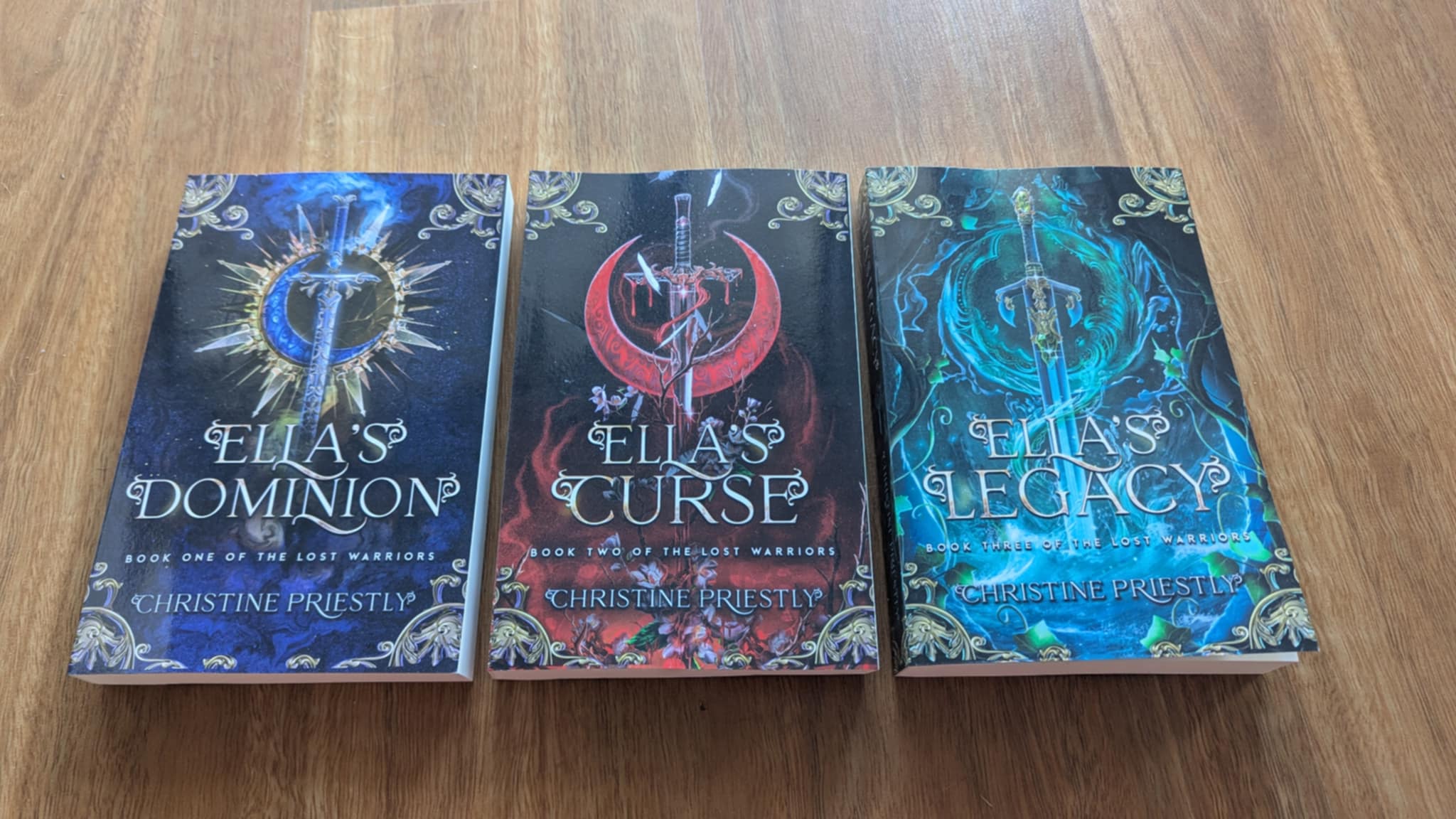 Paperback copies of Ella's Dominion, Ella's Curse and Ella's Legacy